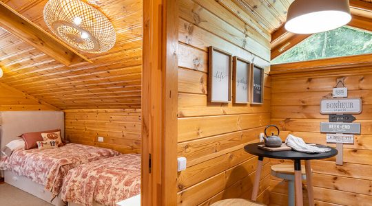 Small stylish kitchen and cozy bedroom in wooden house. Village life concept